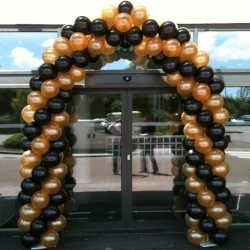 A balloon arch made from black and bronze coloured balloons