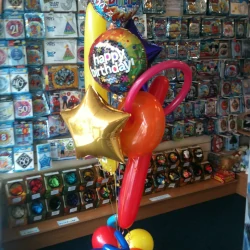 A red balloon pillar topped with 'Happy Birthday' balloons