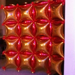 A wall made of interlocking red and yellow foil balloons
