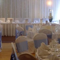 Wedding reception with luxury backdrop, chaircovers and pale blue sashes