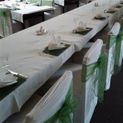 Large square-backed chairs with lycra chair covers and organza sashes